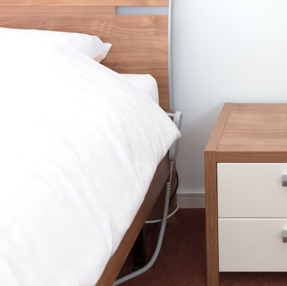 Lit électrique avec draps blancs et table de chevet - lit électrique mauvais pour la santé